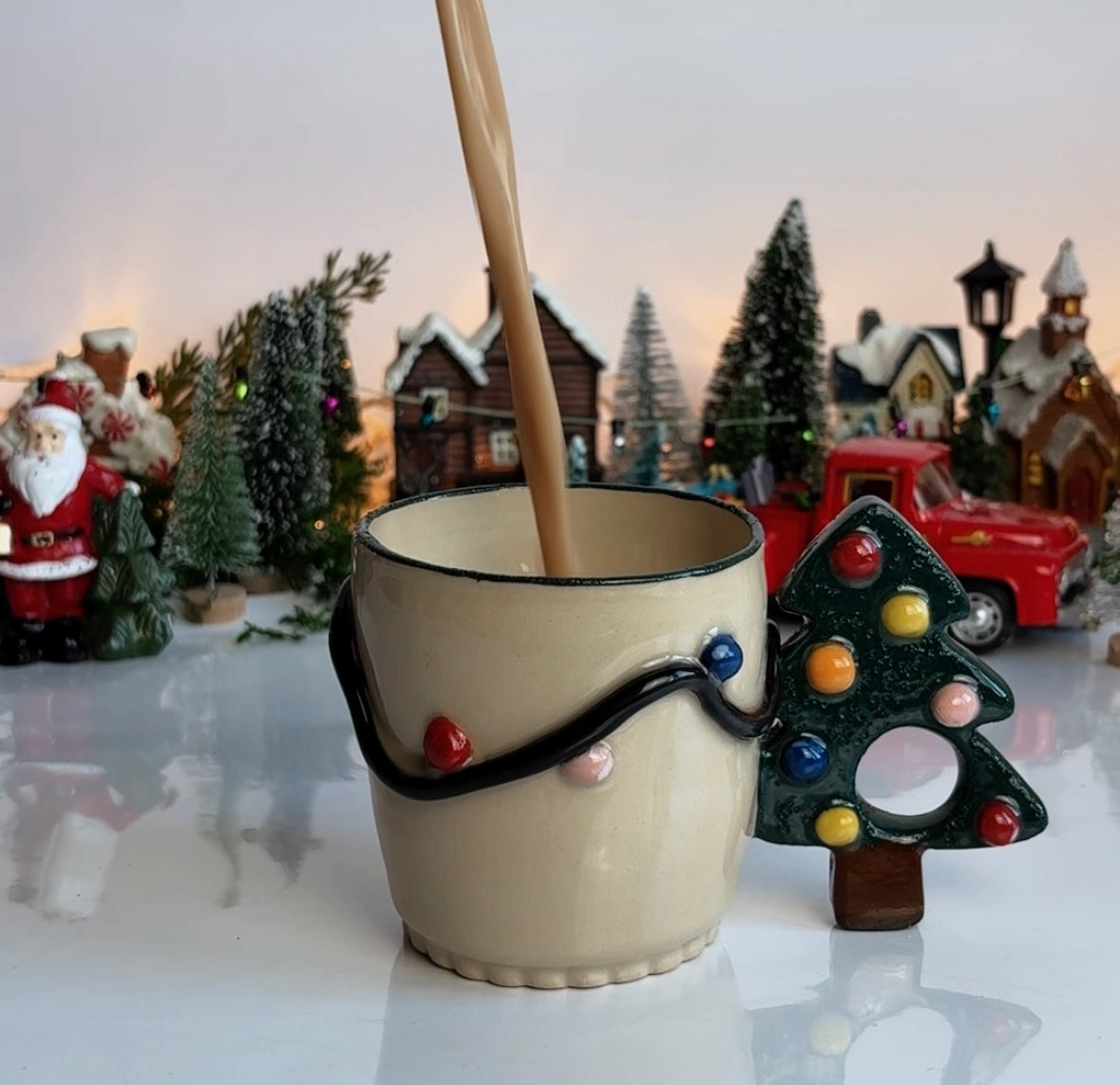 Decorative mug with a Christmas tree design on a table with a festive background.